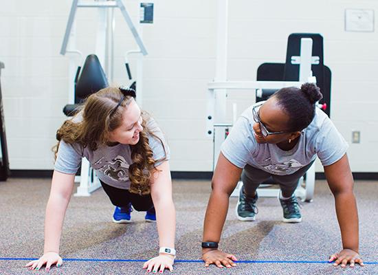 两个博彩平台推荐的学生在健身房锻炼. 